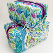 Colorful floral-patterned pouches with 'Amanda Murray' branding on a white background
