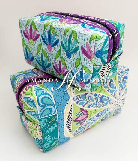 Colorful floral-patterned pouches with 'Amanda Murray' branding on a white background