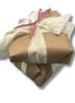 Package wrapped in brown paper with a white ribbon on a white background