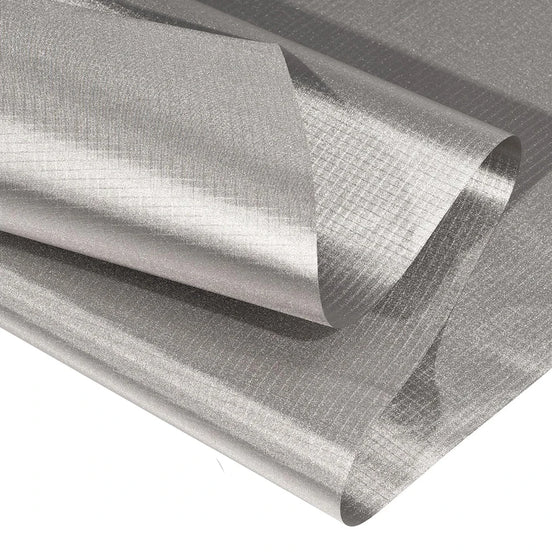 A close-up of a rolled sheet of metallic silver material with a textured, grid-like surface, shown against a plain white background.