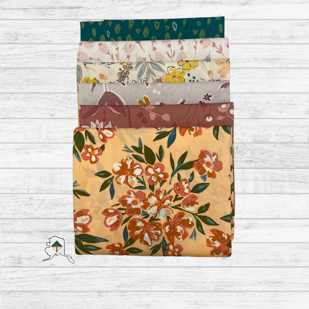 Set of floral-patterned fabric swatches on a wooden surface