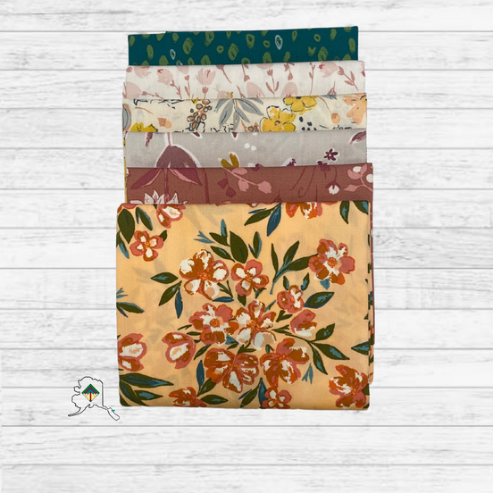 Set of floral-patterned fabric swatches on a wooden surface