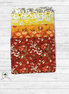 Stack of floral fabric panels in various colors on a wooden surface