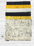 Stack of fabric panels with abstract face designs on a white wooden surface