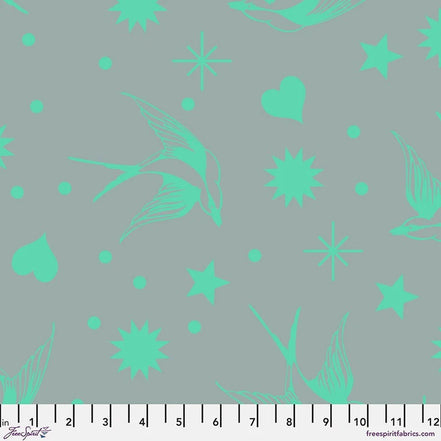 Fabric with aqua floral and star patterns on a gray background, featuring a ruler at the bottom.