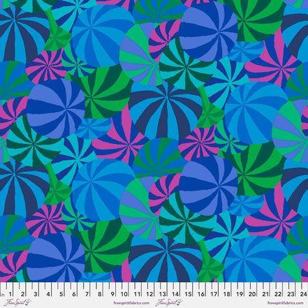 Colorful pattern of blue, green, and pink circles on a fabric swatch with a ruler at the bottom.