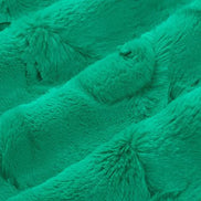 Close-up of teal textured fabric with pom-pom details