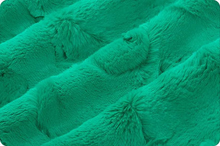 Close-up of teal textured fabric with pom-pom details
