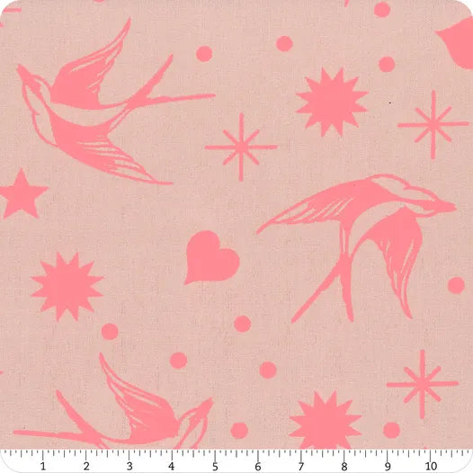 Fabric with pink birds and starburst patterns on a beige background, ruler at the bottom.