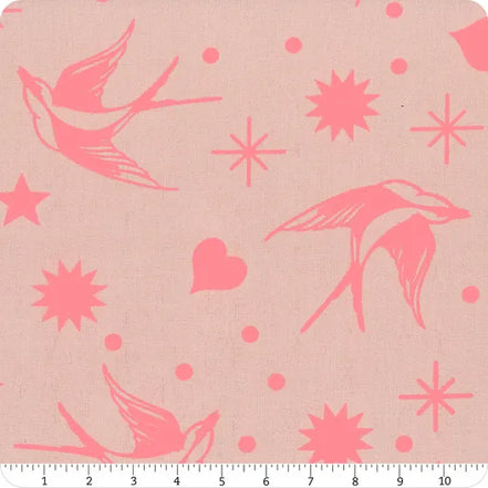 Fabric with pink birds and starburst patterns on a beige background, ruler at the bottom.
